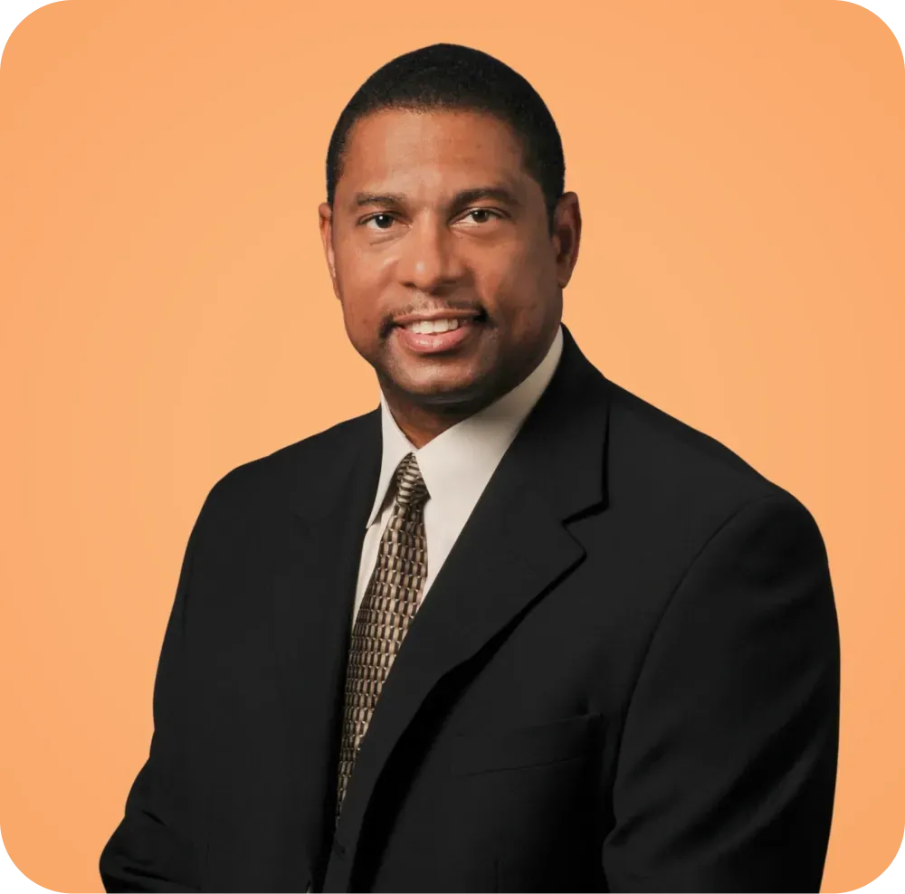 A man in a suit and tie is smiling for the camera