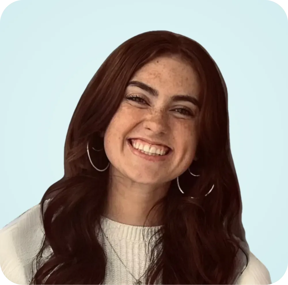 A woman with long brown hair and freckles is smiling for the camera.
