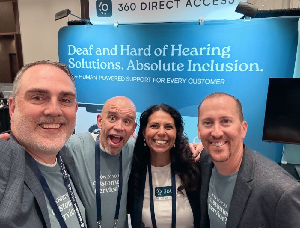 A group of people standing in front of a sign that says deaf and hard of hearing solutions absolute inclusion