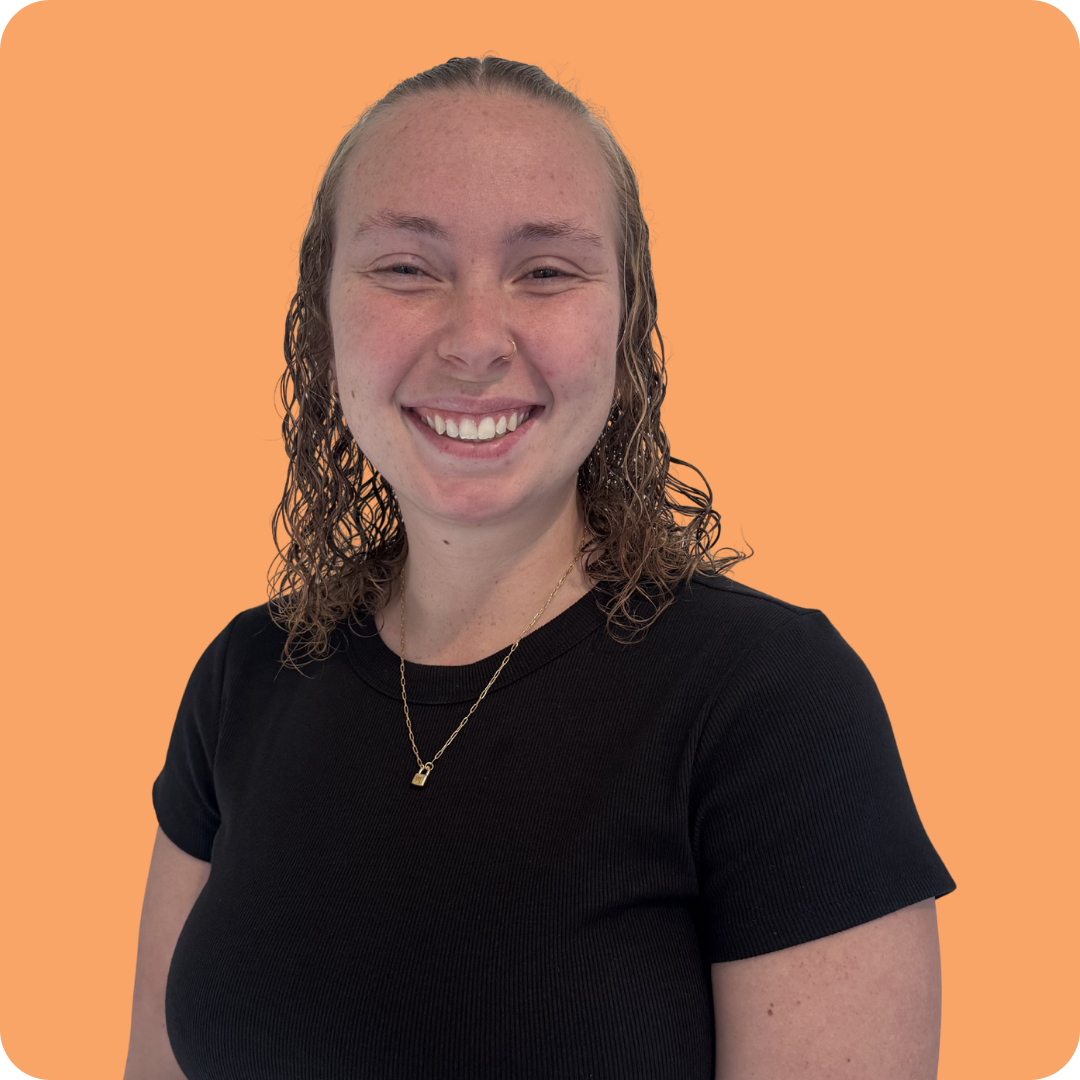 A man with a beard is wearing a black shirt and smiling.