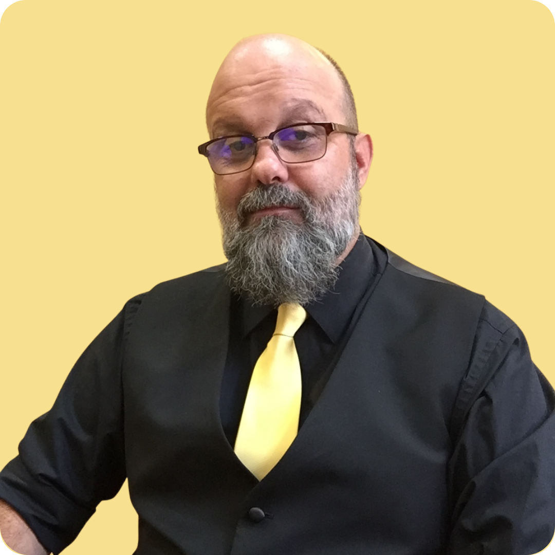 A man with a beard wearing glasses and a yellow tie