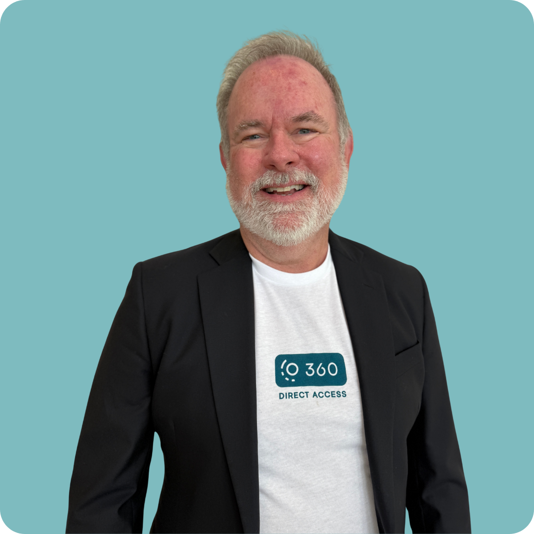 A man with a beard is smiling with his arms crossed and his hand on his chin.
