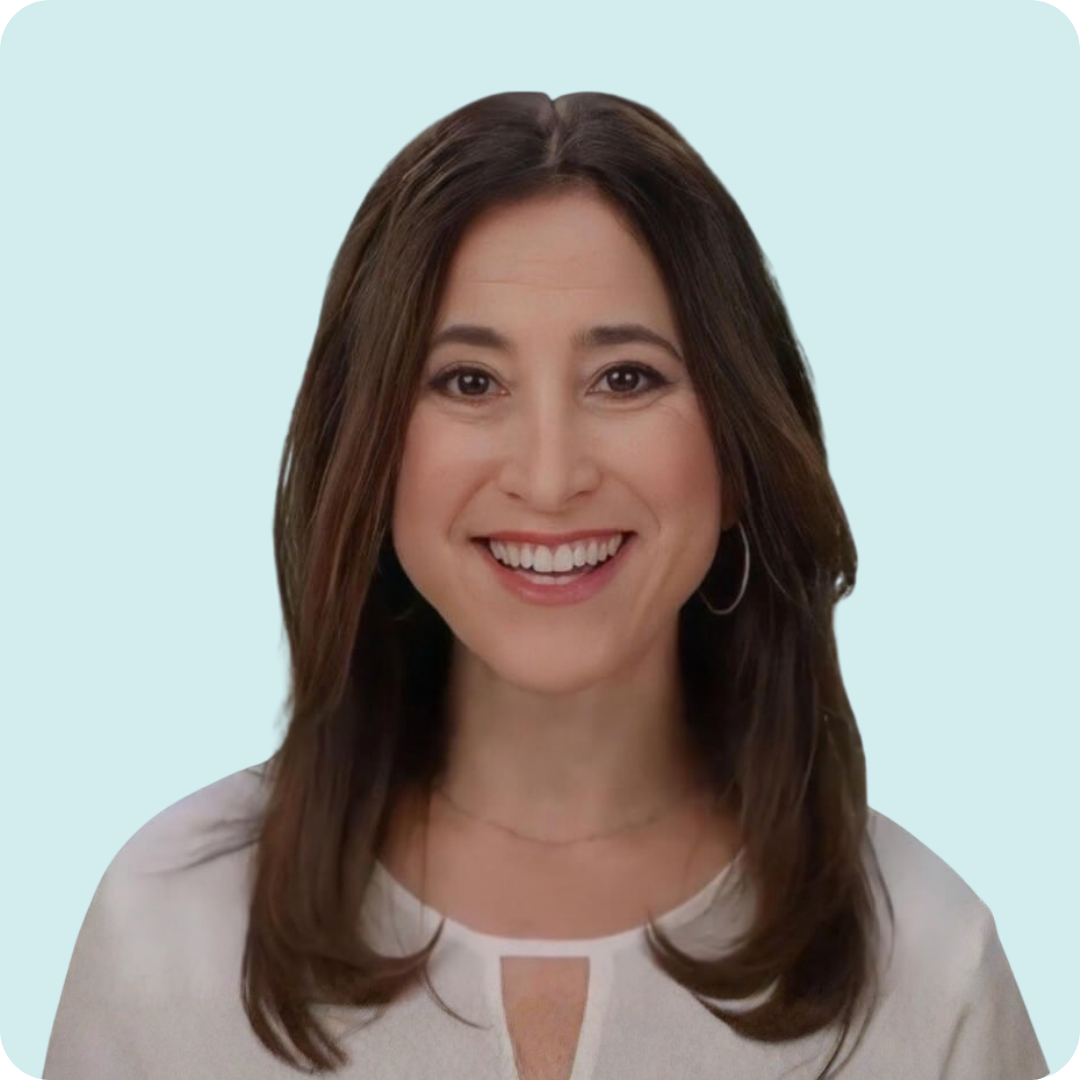A woman smiling with brown hair. She is wearing a white shirt.