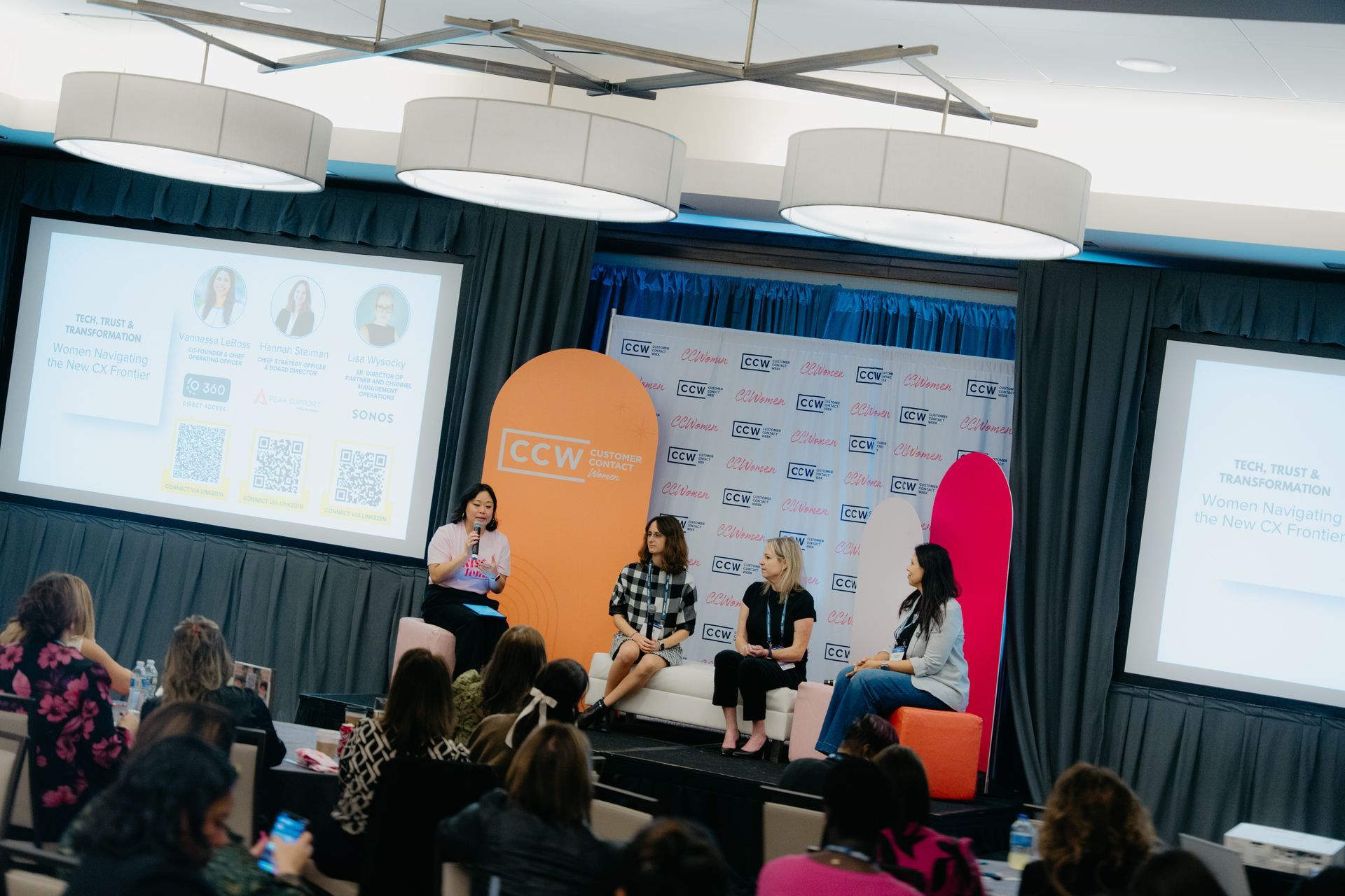 A panel of four women seated on stage