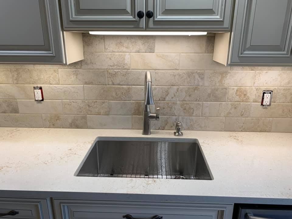 A kitchen with a stainless steel sink and a faucet