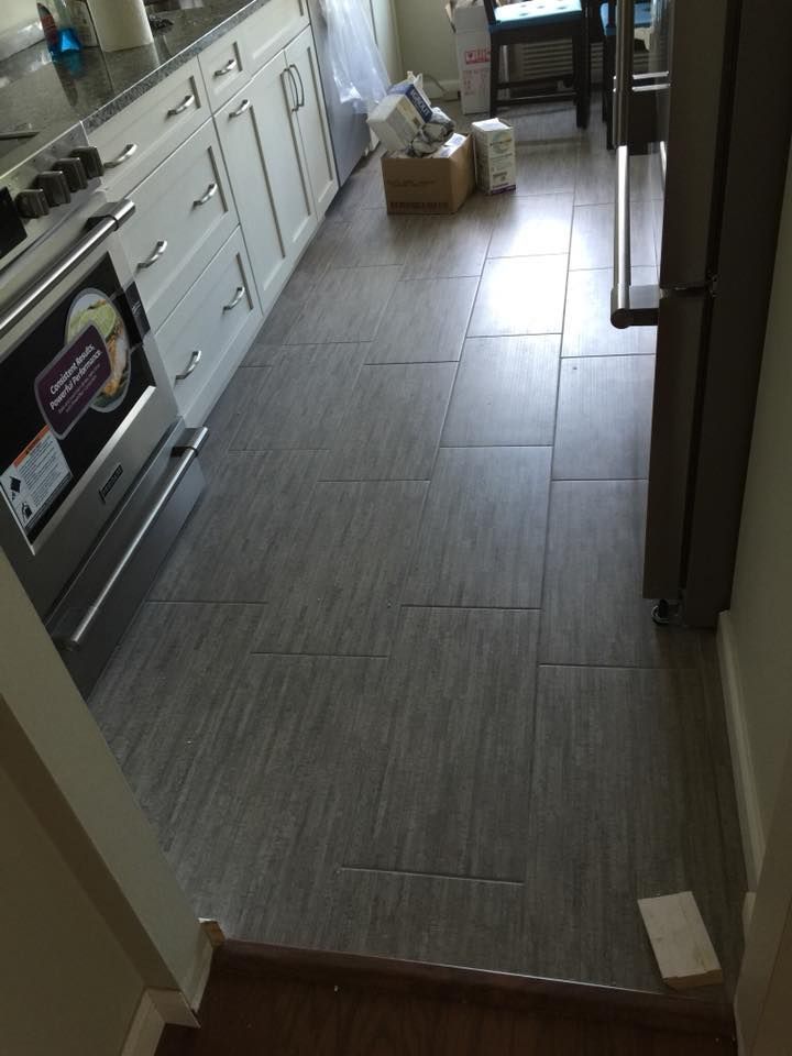 A kitchen with a tiled floor and a stove and refrigerator