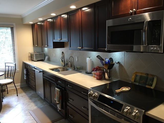 Kitchen with dark brown cabinets, stainless steel appliances, light countertops, and a stovetop.