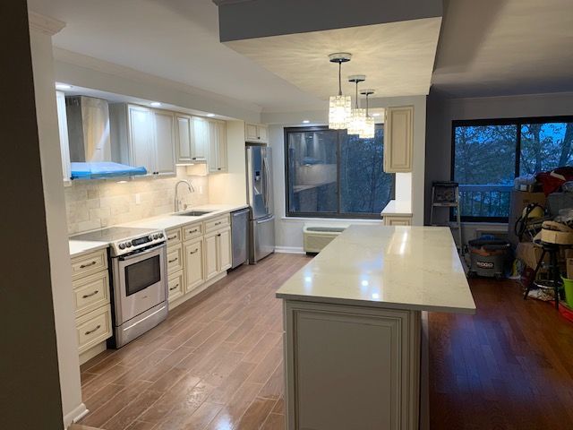 Newly renovated kitchen with light cabinets, white countertops, and stainless steel appliances.