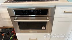 Built-in stainless steel KitchenAid microwave and oven combo in a white cabinet.