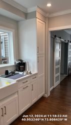 White kitchen with cabinets, a sink, and a doorway with sliding barn doors.