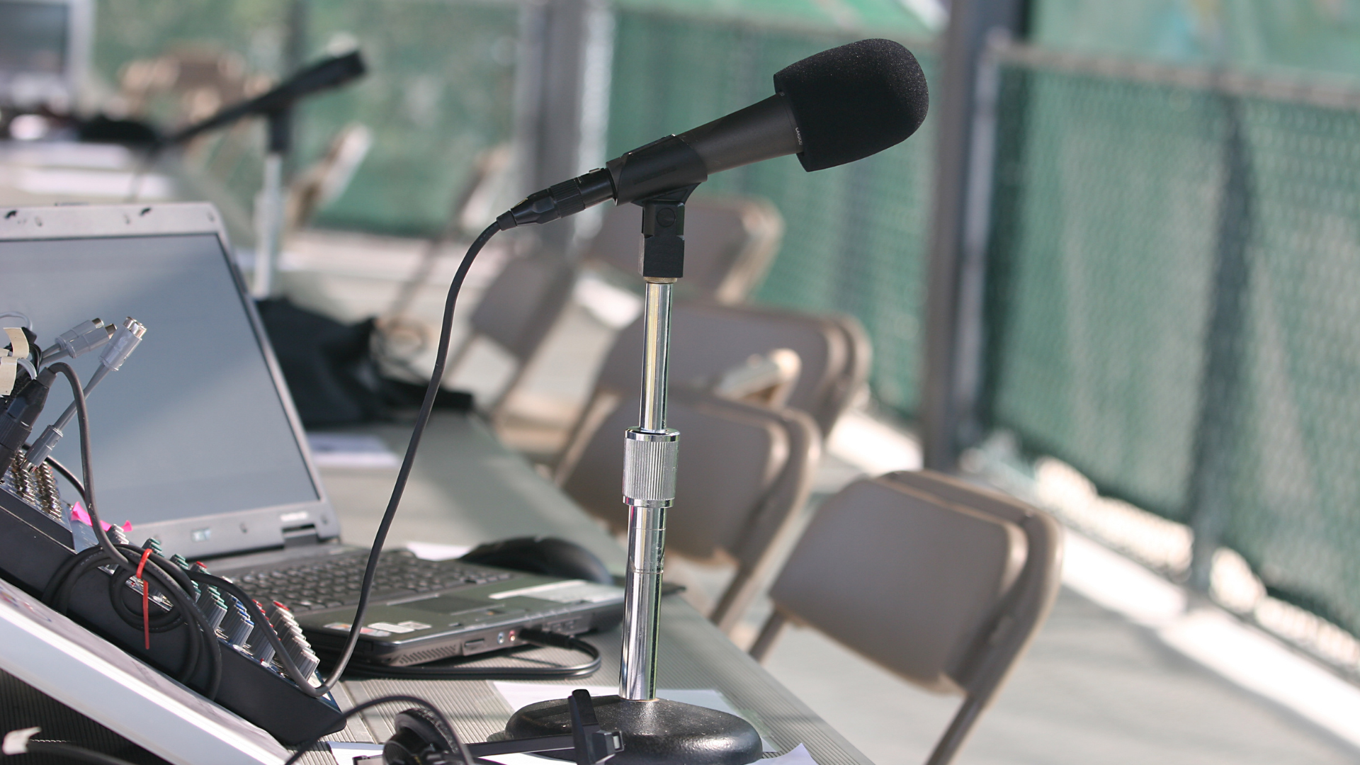 A microphone is sitting on a table next to a laptop