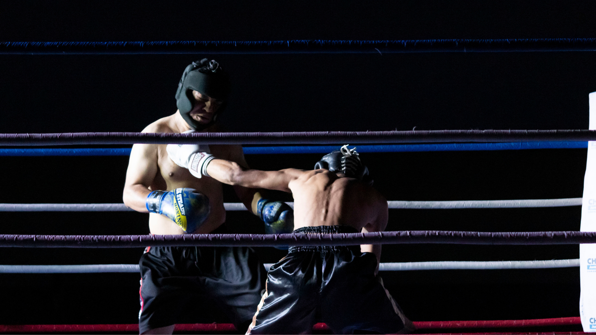 Two men are boxing in a boxing ring.