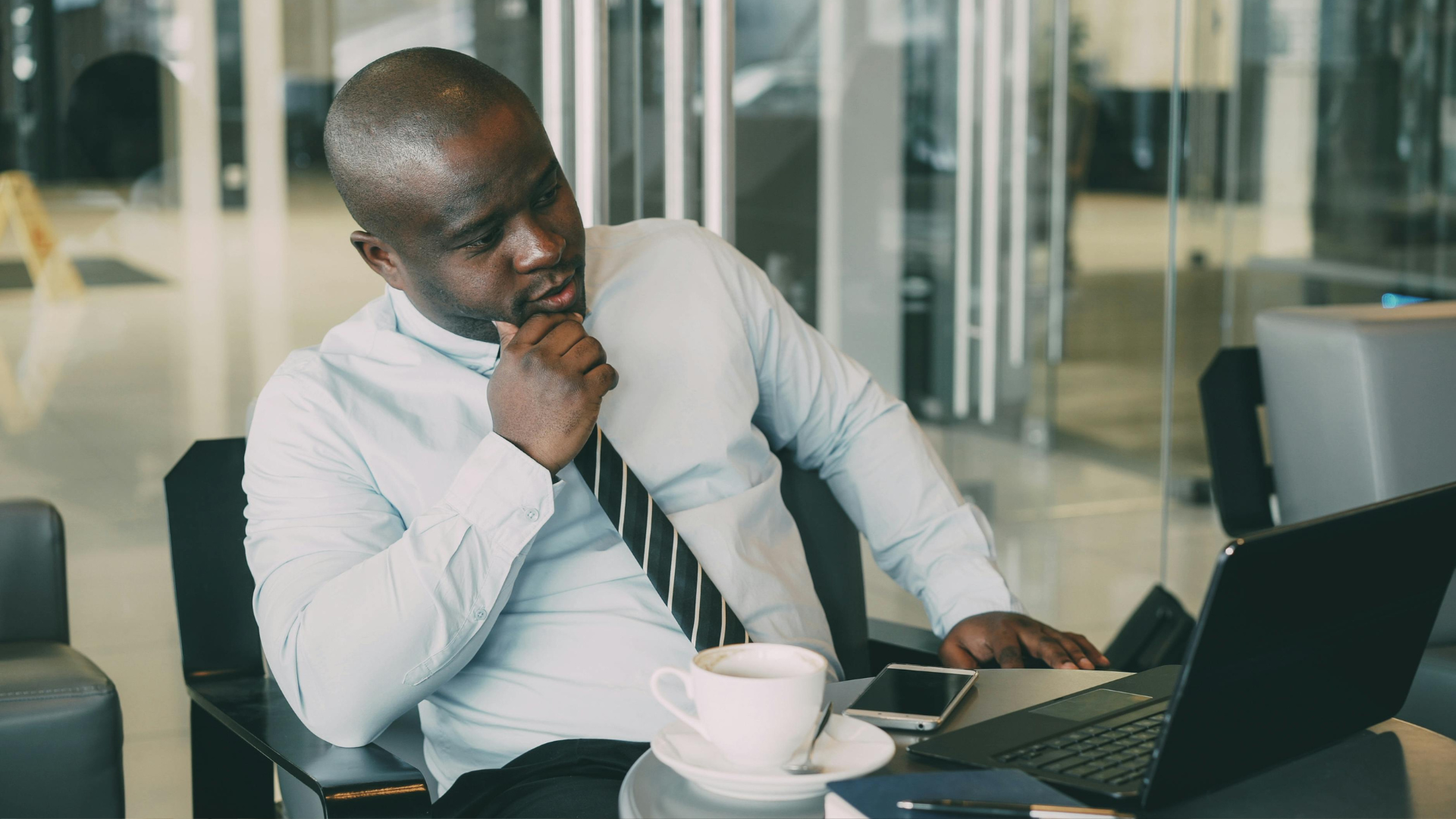 Two coworkers in a meeting reviewing documents across a desk in a bright office