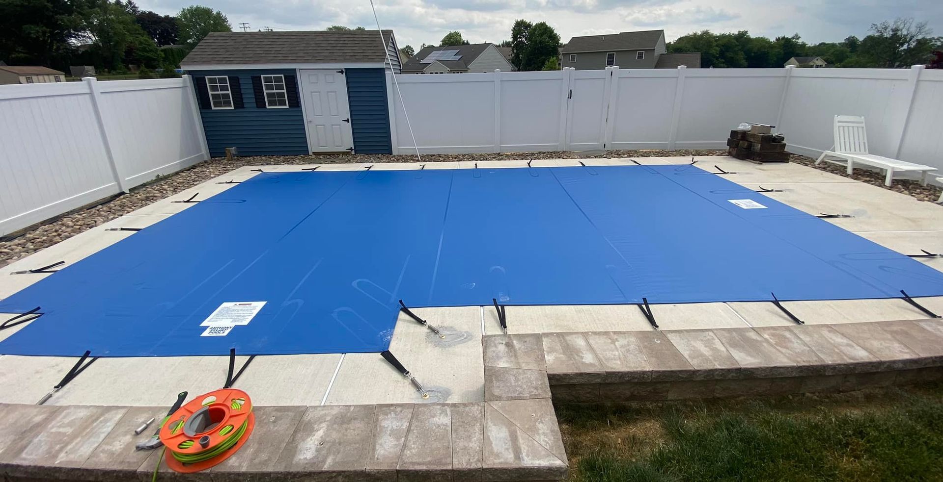 A large swimming pool with a blue cover on it.