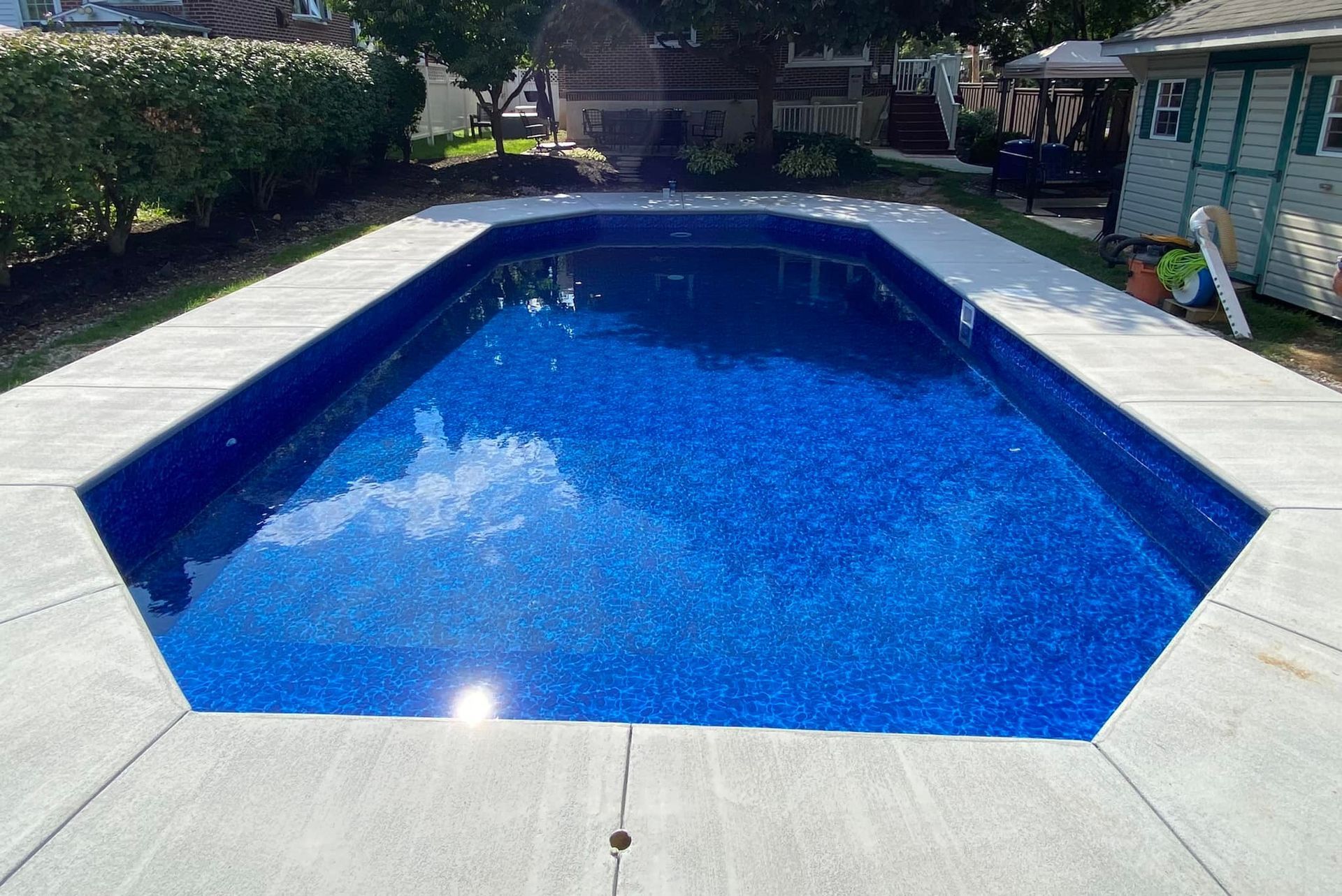 A large swimming pool with blue water and a concrete deck