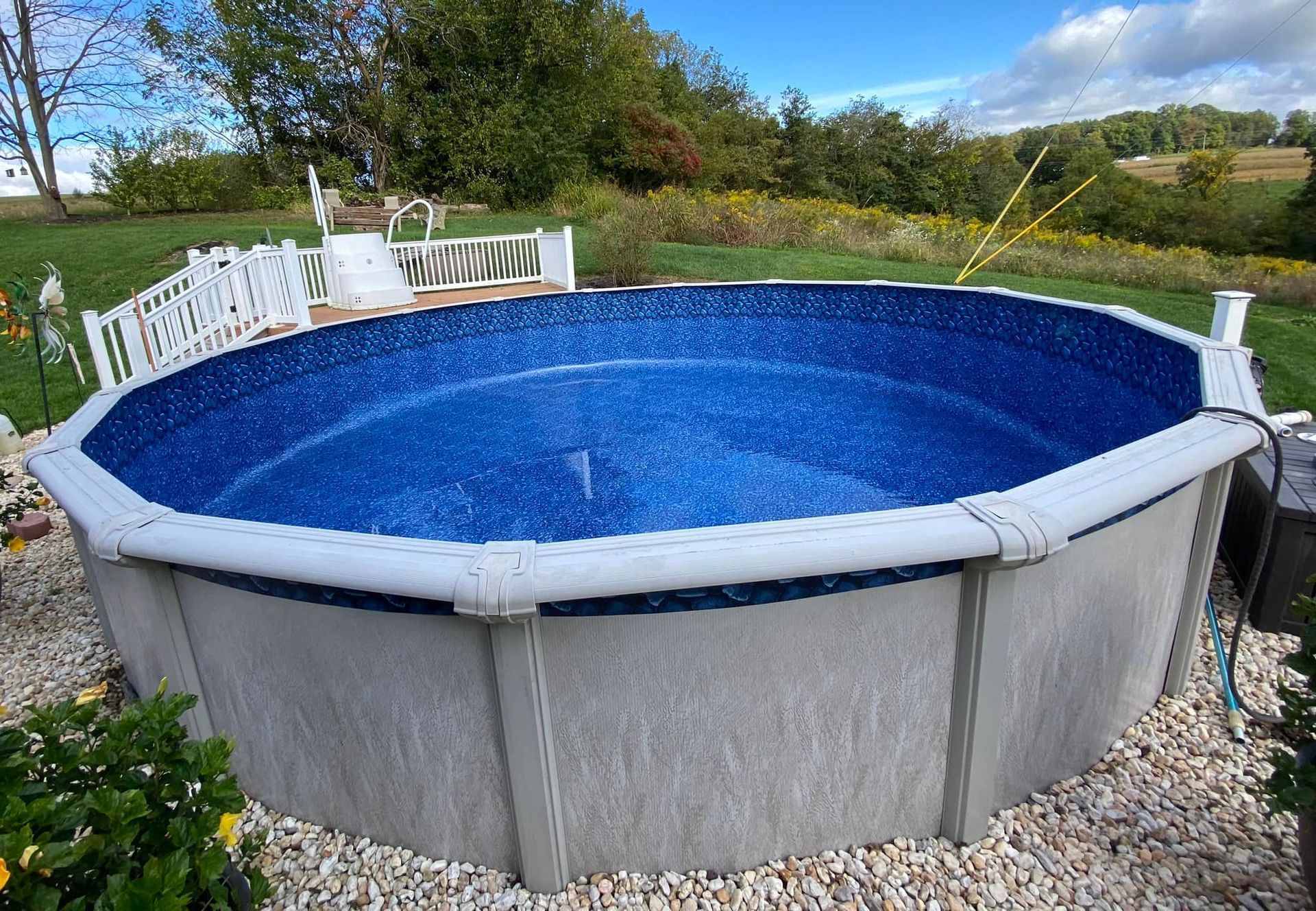 A large round swimming pool with a blue liner