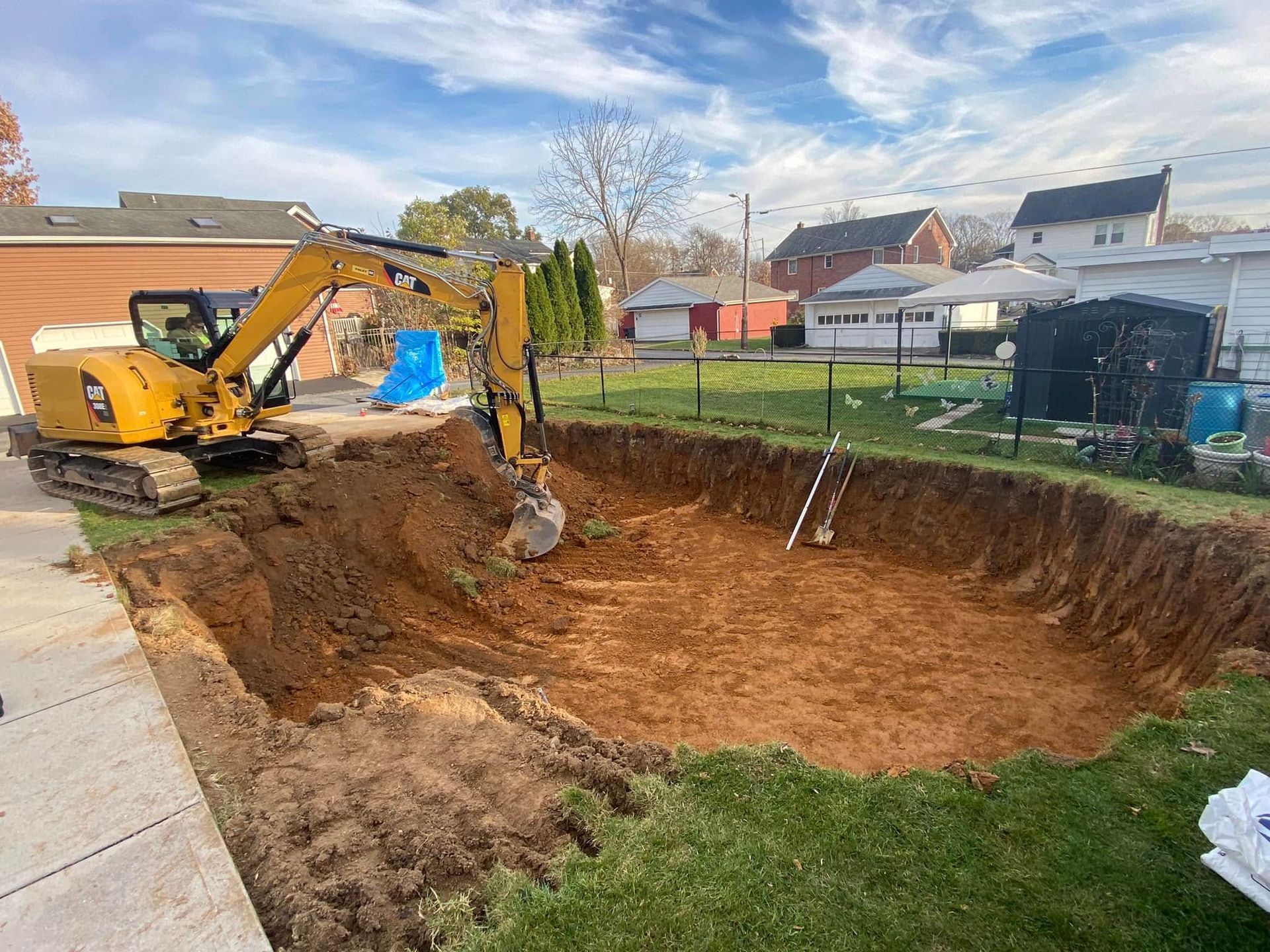 A yellow excavator is digging a large hole in the ground.