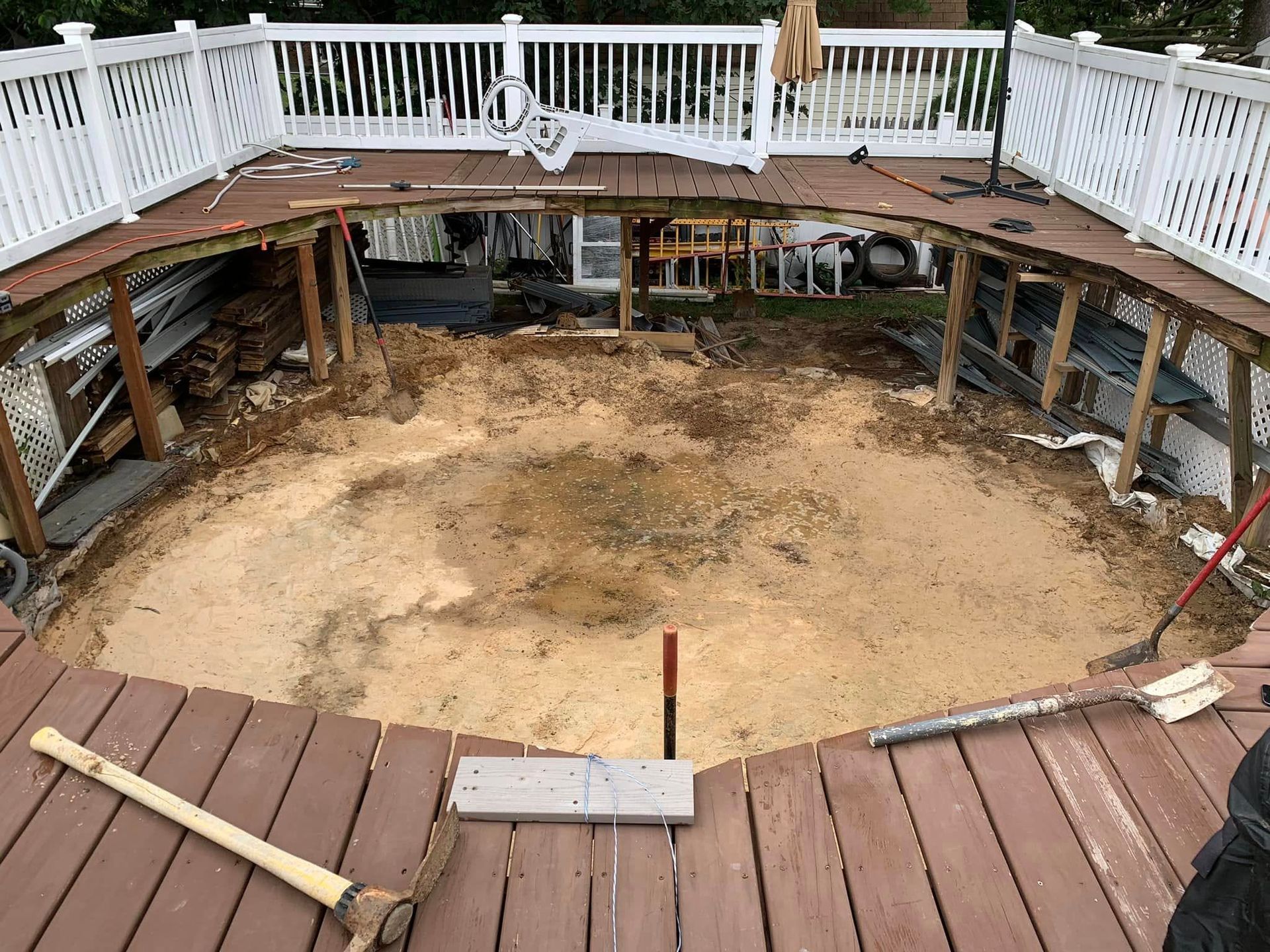 A wooden deck with a pool in the middle of it being built.
