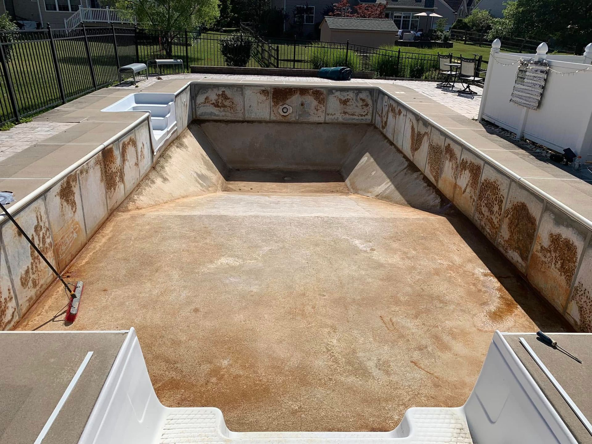 An empty swimming pool with a broom in it