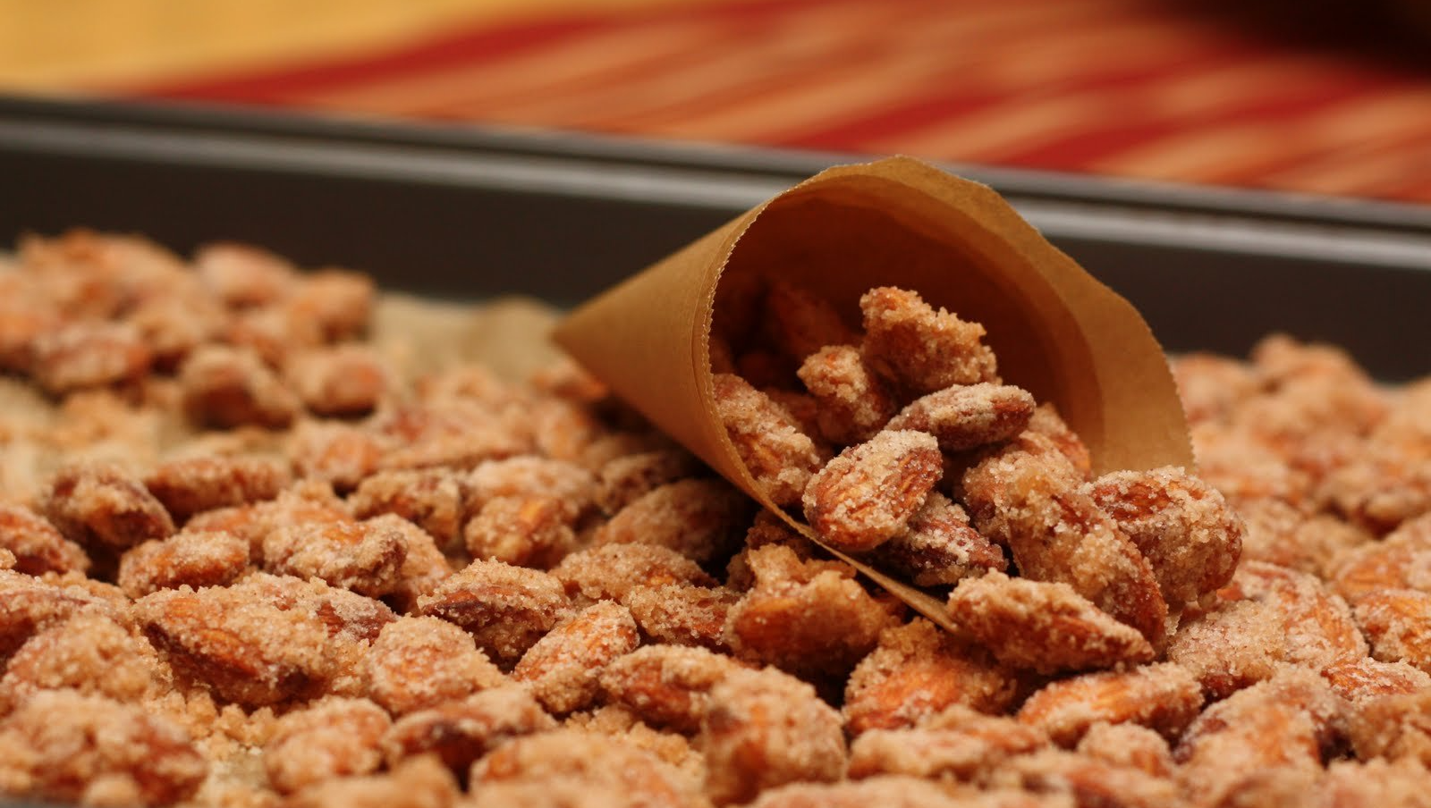 A cone filled with nuts is sitting on top of a pile of nuts.