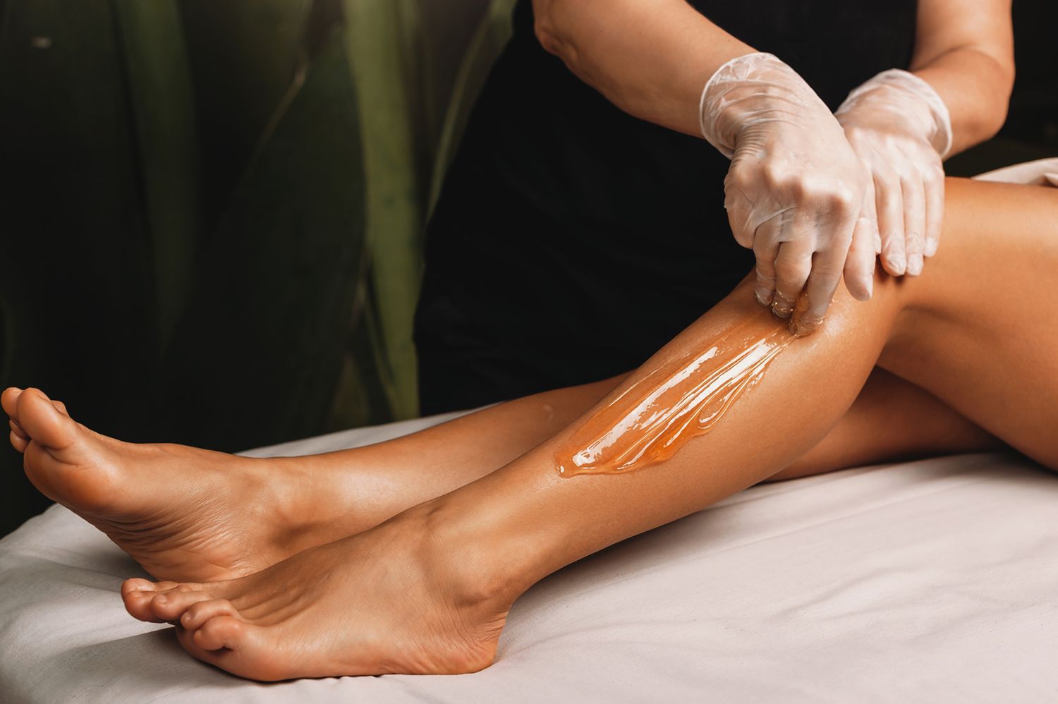 A woman is getting her legs waxed in a beauty salon.