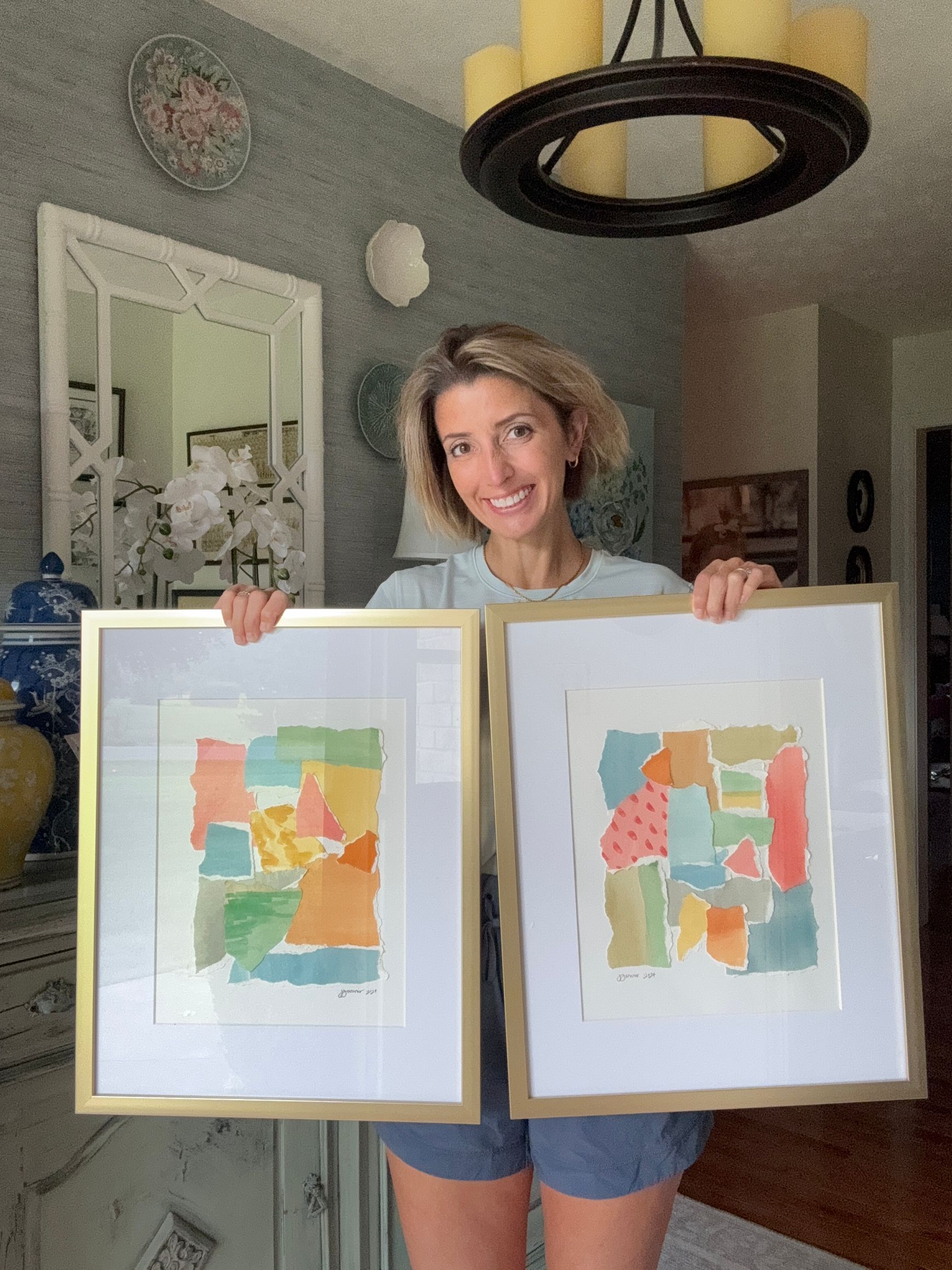 Jenni holding pair of watercolor torn paper collages with gold frames