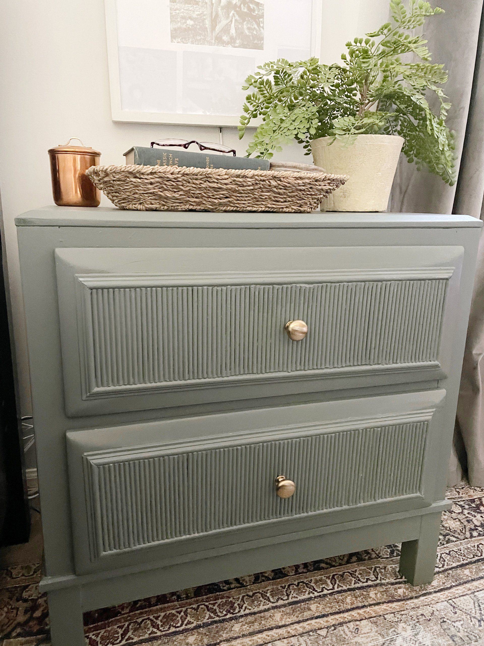 dark green fluted wood nightstand with gold knobs