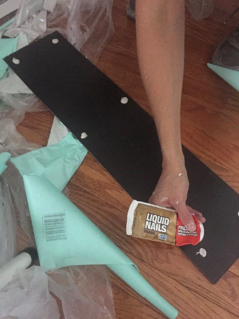 putting liquid nails on vinyl plank for shiplap wall