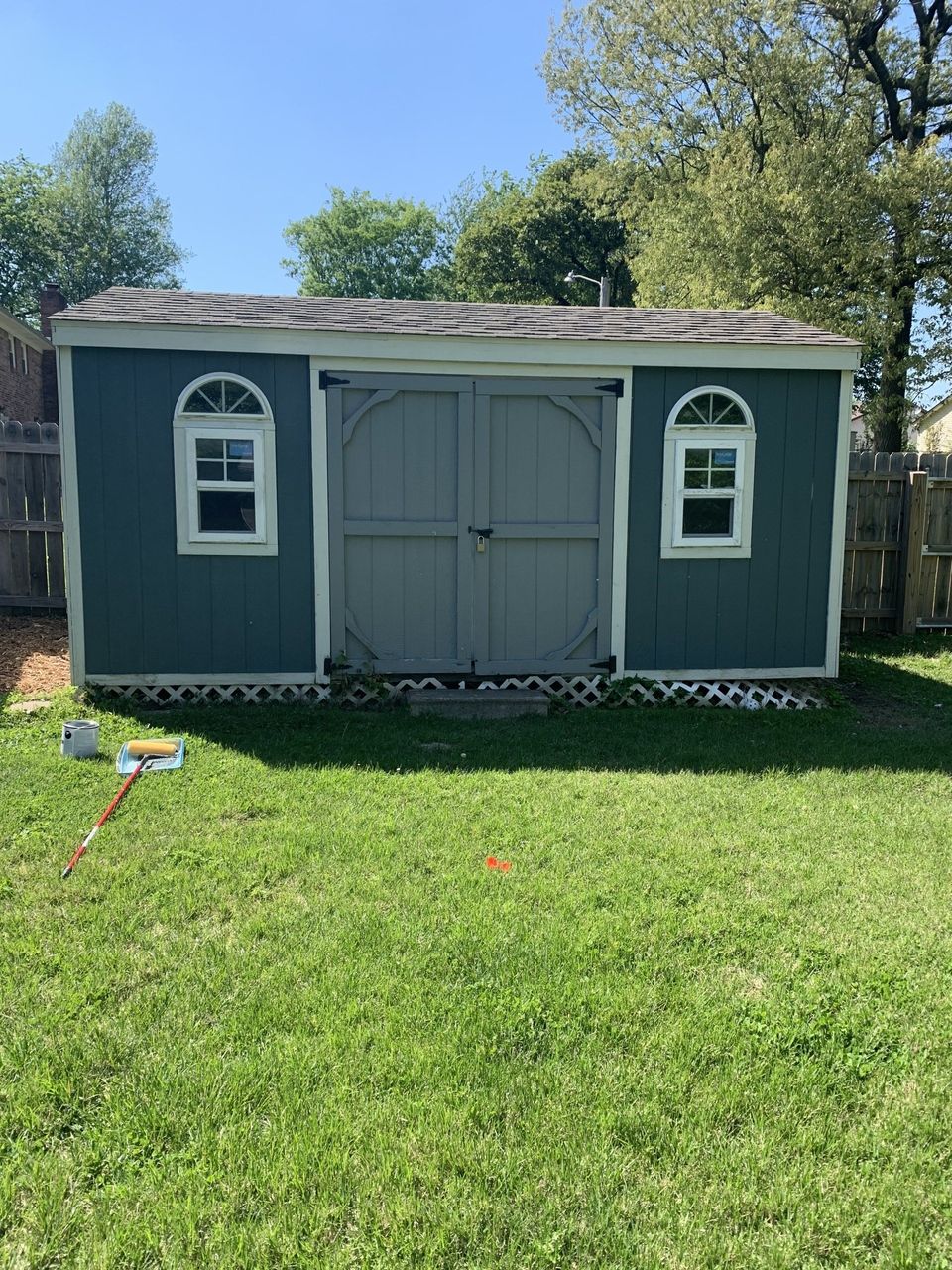 dark teal blue and tan backyard shed before