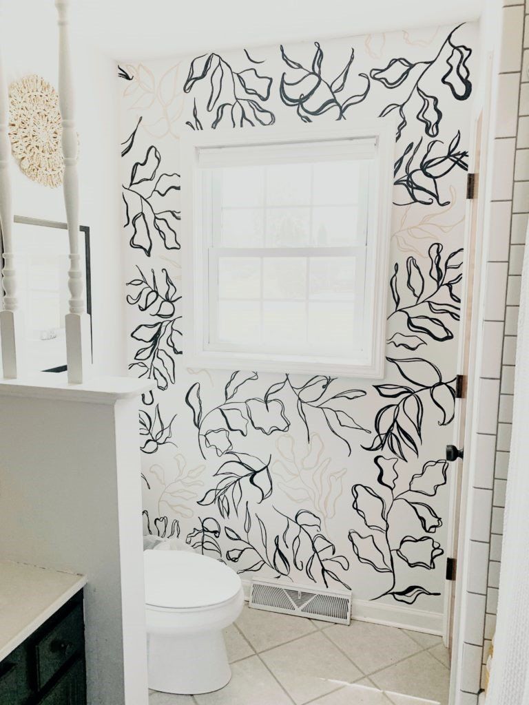 white bathroom with hand painted black and tan branches