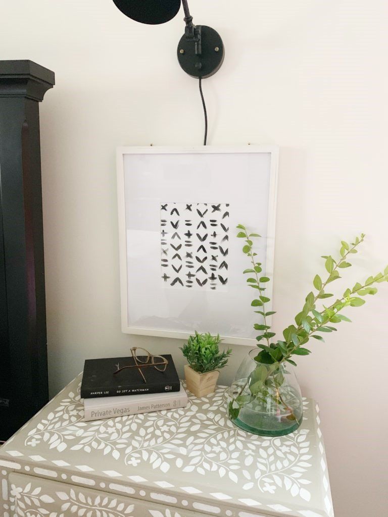 DIY black and white abstract art in white matted frame above painted bone inlay nightstand