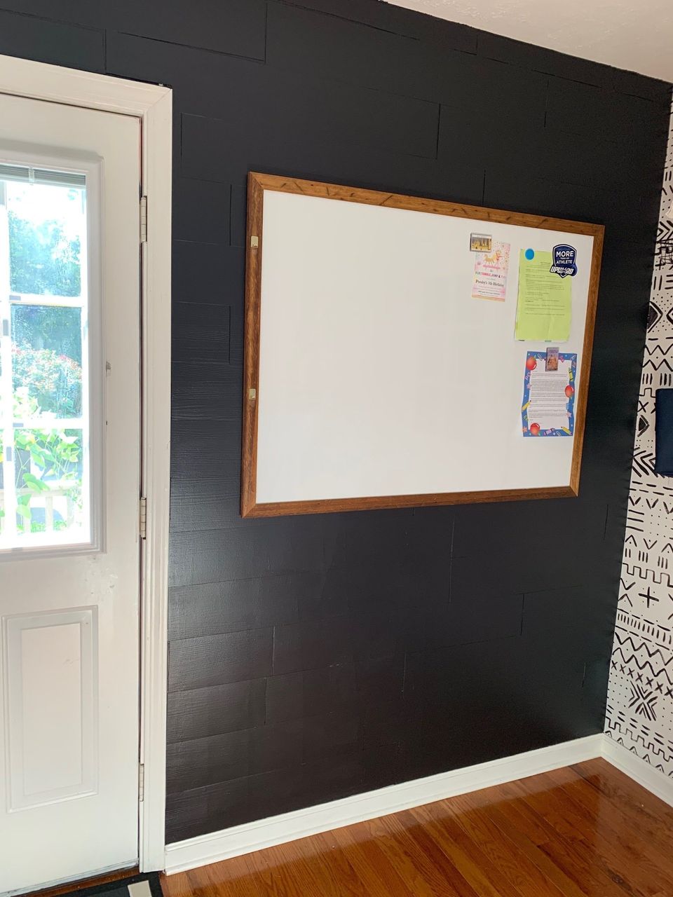black no nails shiplap accent wall in laundry room with big white board