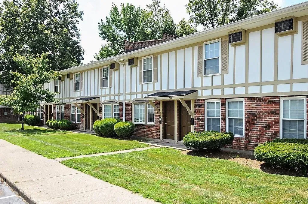 A row of apartment buildings with a sidewalk in front of them