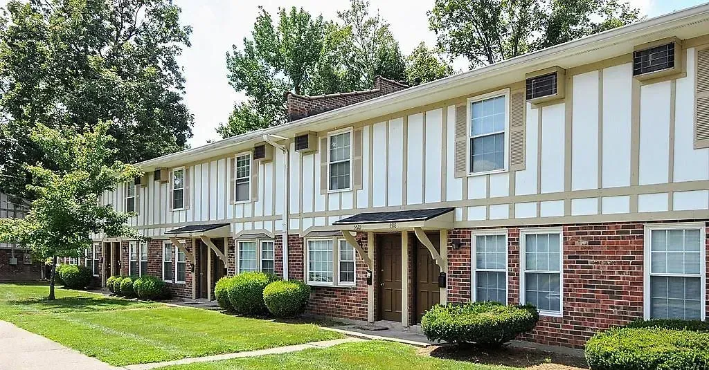 A brick apartment building with a white trim and a lot of windows