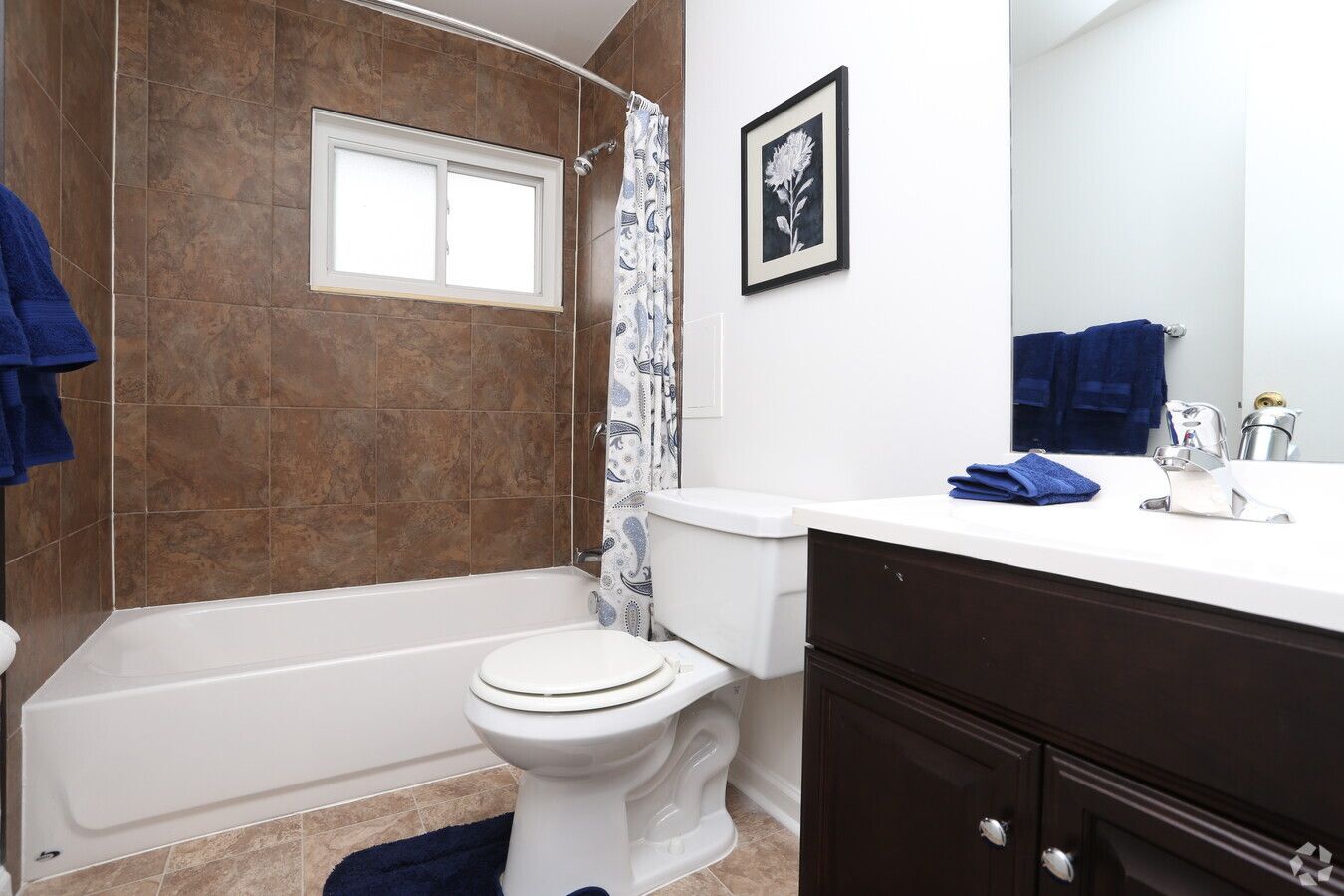 A bathroom with a toilet , sink , tub and mirror