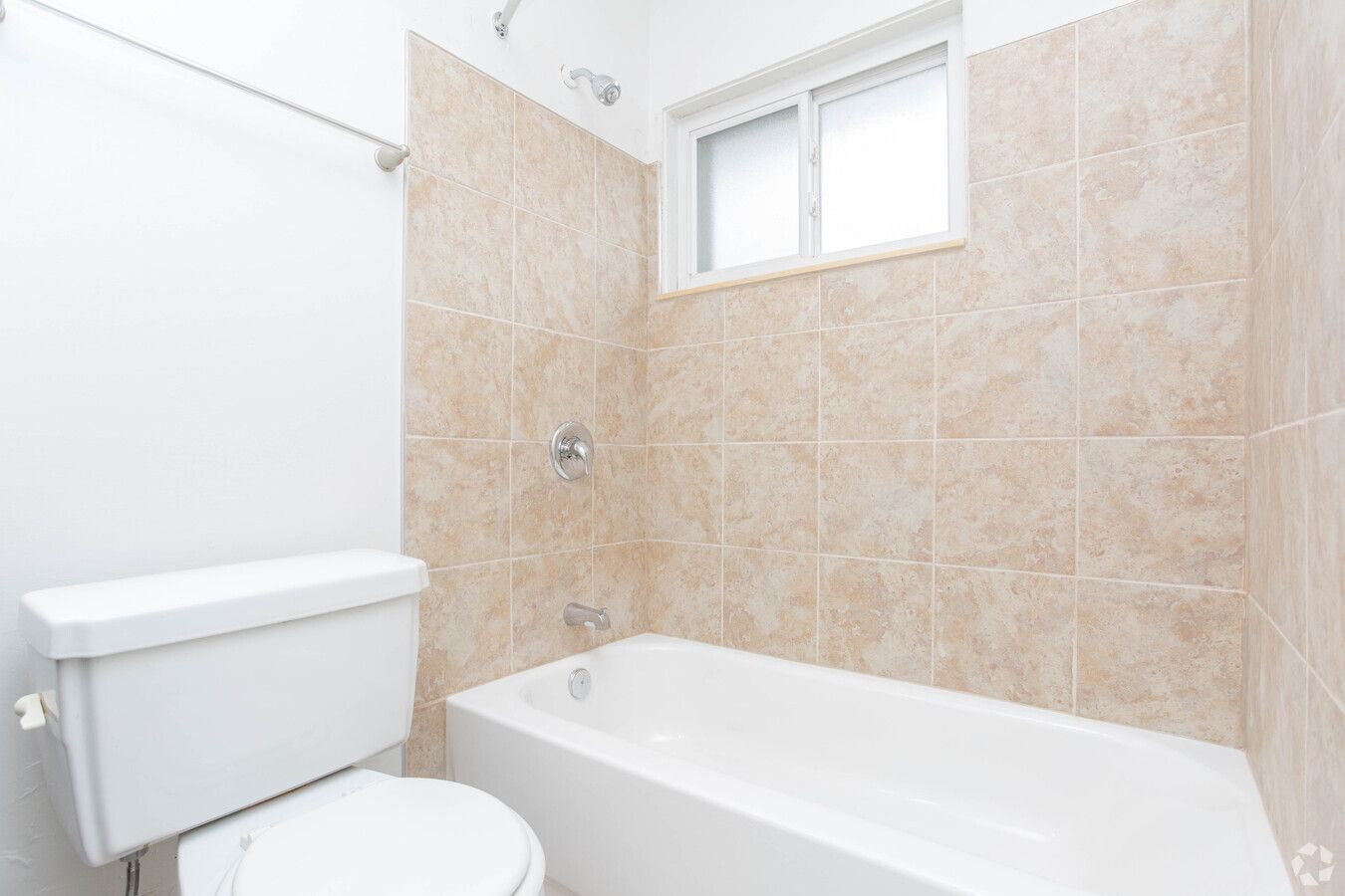 A bathroom with a toilet , bathtub and shower.