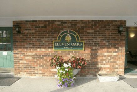 A brick wall with a sign that says eleven oaks on it