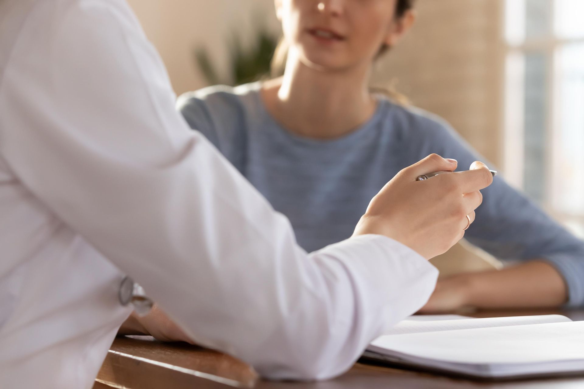 A doctor is talking to a patient who is sitting at a table.