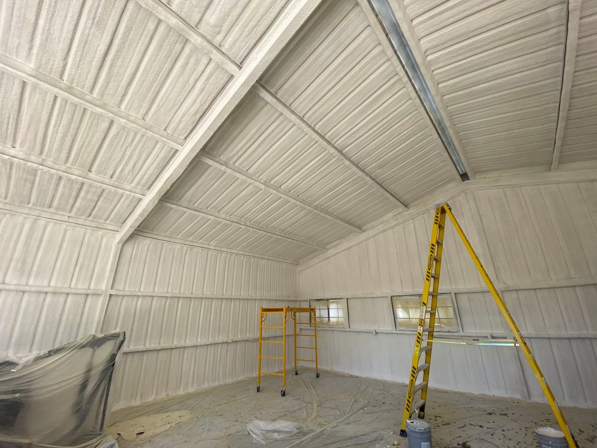 Interior of a metal building with spray foam insulation on the walls and ceiling. 