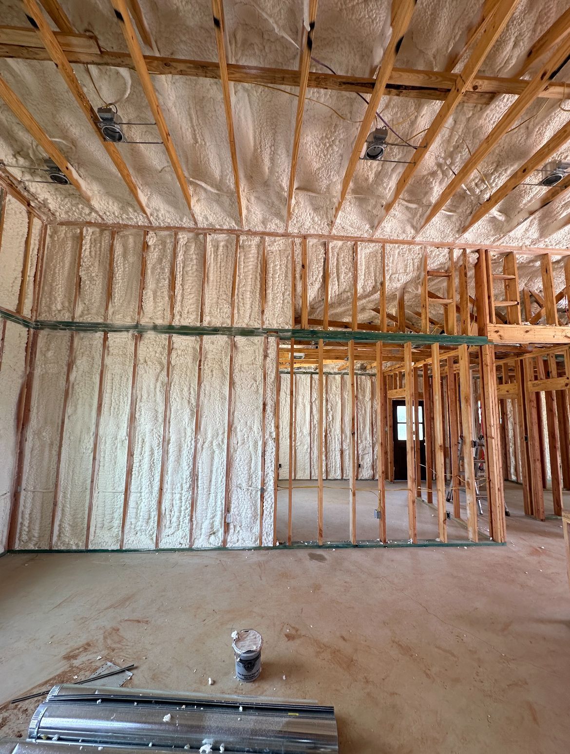 Interior view of a building under construction, walls and ceiling insulated with foam.