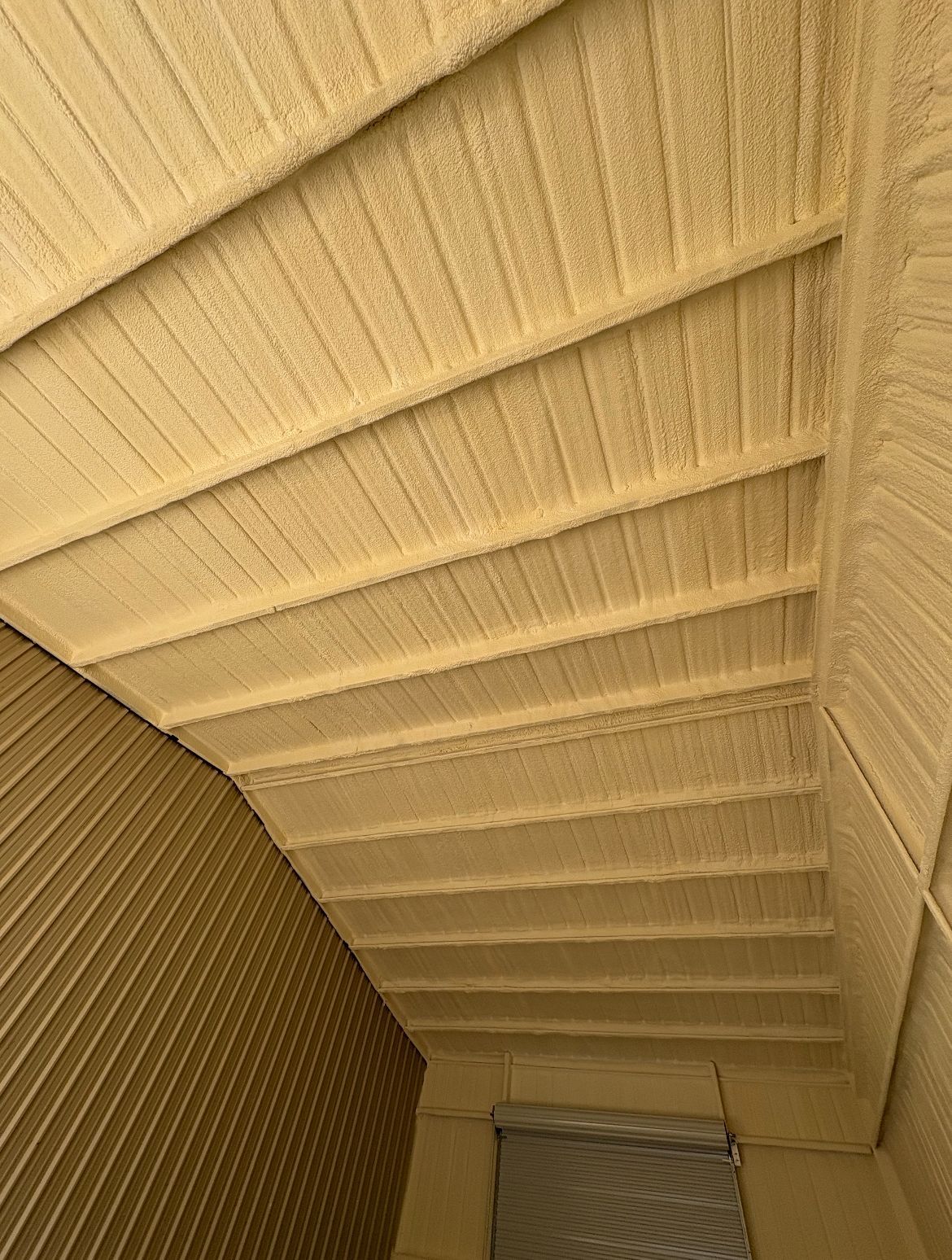 Yellow textured ceiling with horizontal beams, angled view.
