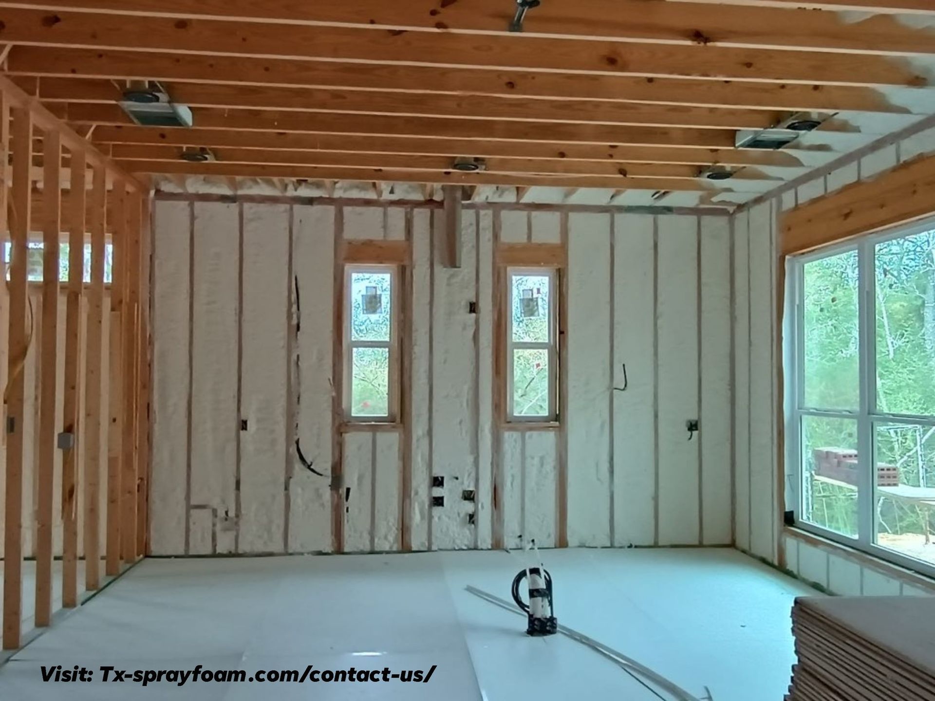 Interior of a room under construction with spray foam insulation on the walls.