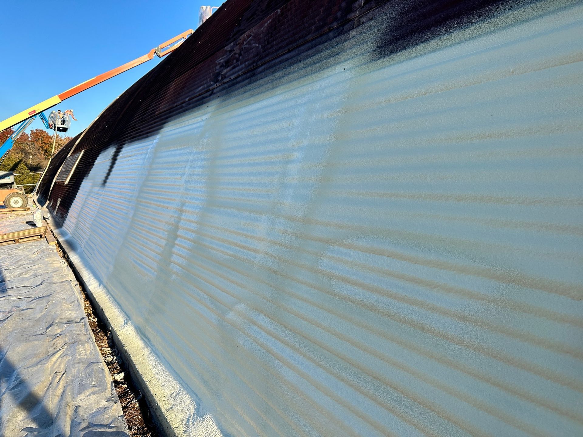 Exterior wall of a building being constructed with a 3D printer; gray concrete with visible layering.