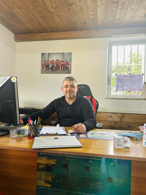 Un uomo è seduto alla scrivania davanti a un computer in un ufficio.