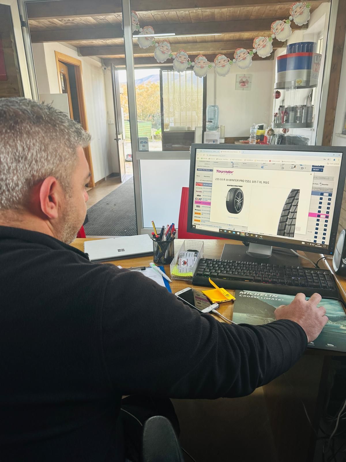 Un uomo è seduto alla scrivania e guarda lo schermo del computer.