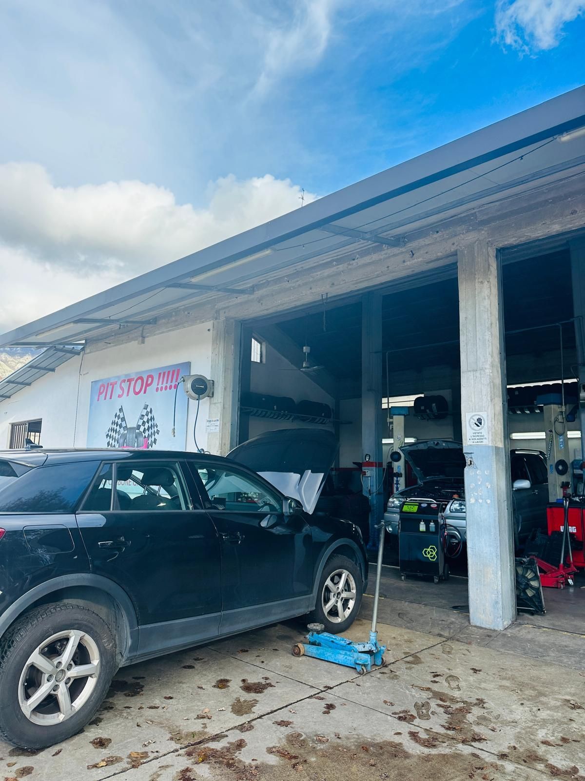 Un'auto nera è parcheggiata davanti a un garage.