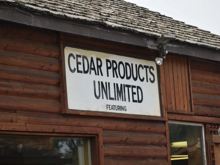 A wooden building with a sign that says cedar products unlimited.