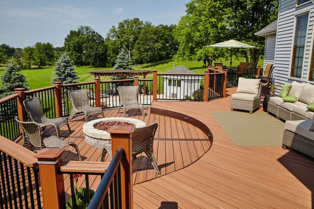 A large wooden deck with a fire pit in the middle.