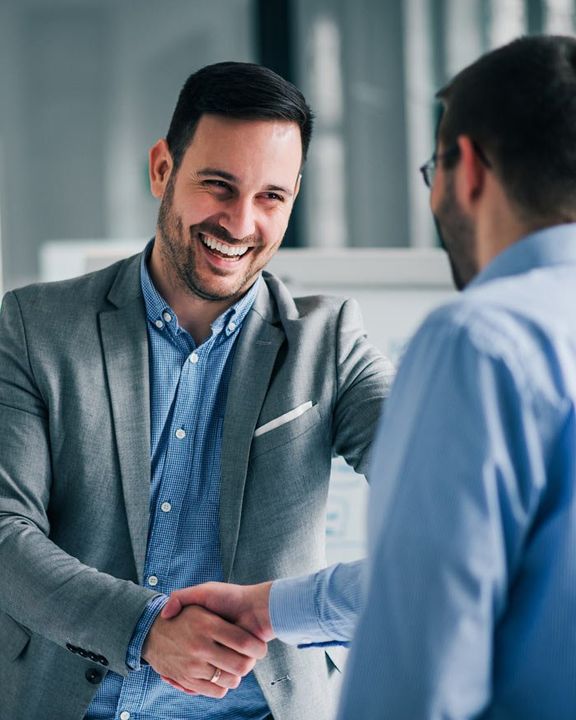 smiling business men shaking hands