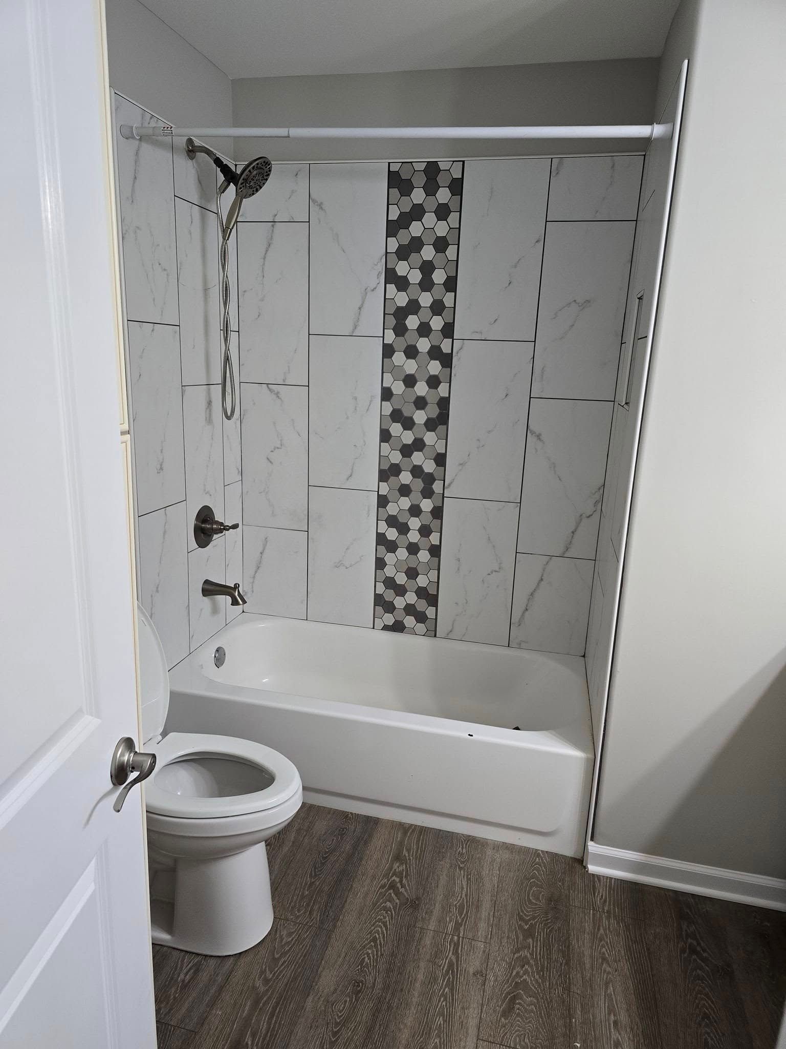 A bathroom with a toilet , bathtub and shower.